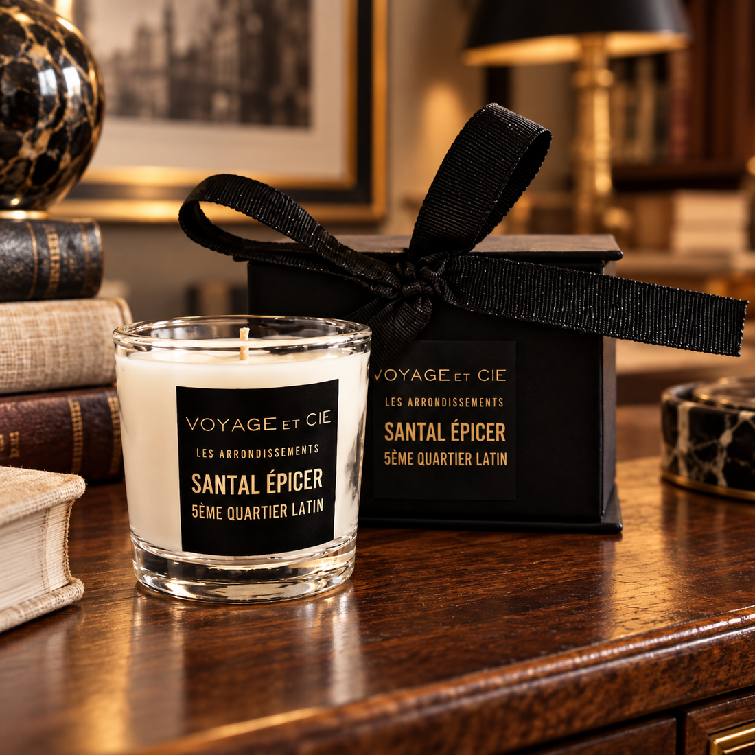 Voyage et Cie Santal Épicé votive candle and gift box in a warm private study
